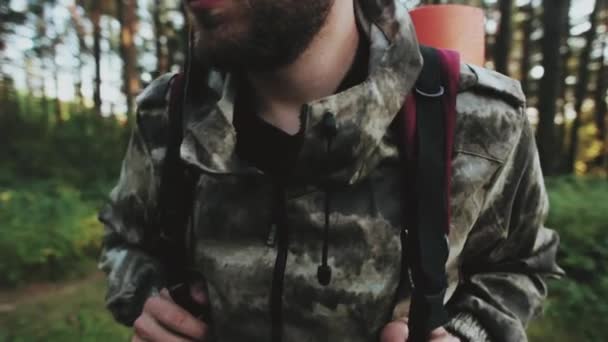 Homme en camouflage debout dans la forêt avec sac à dos et regarder autour. Touriste mâle choisit le chemin à parcourir . — Video