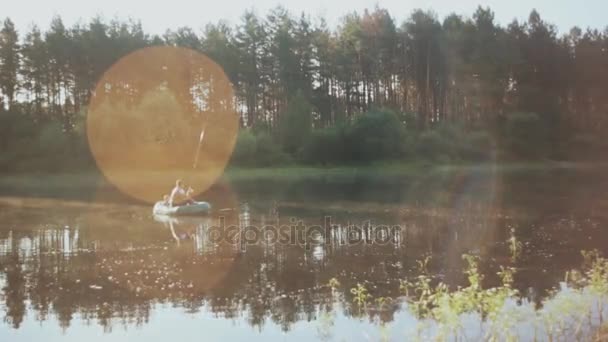 Två man fiske tillsammans i gummibåt på morgonen. Vackra landskap med skog, sjö och solen strålar. — Stockvideo