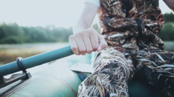 Bliska męskich rąk bierze wiosła i wiersze. Człowiek siedzi w gumowe łódź i zawirowań wiosła w słoneczny dzień. — Wideo stockowe