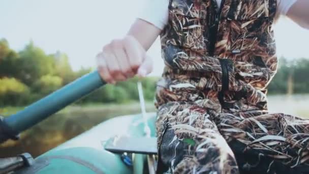 Close-up beeld van mannelijke handen neemt de peddels en rijen in het bos meer. Man kronkelt de riemen in zonnige dag. — Stockvideo