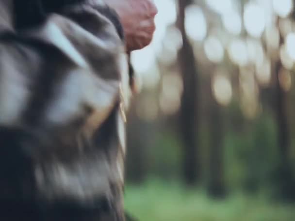 Szczelnie-do góry widok człowieka w kamuflażu skompresowanie kurtkę. Turystyczna mężczyzna z plecaka spędzanie czasu w lesie sam. — Wideo stockowe