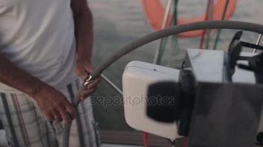 Üst düzey denizci arkasında, bir direksiyon simidi üzerinde sailboard. Adam açık denizde yalnız gemisiyle ederek.