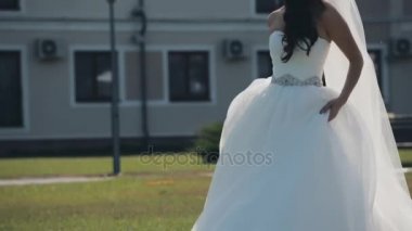 Güzel gelin düğün töreni önce dışında yürüyüş. Kadın durdurur ve gelinlik içinde dönüyor. Ağır çekim.