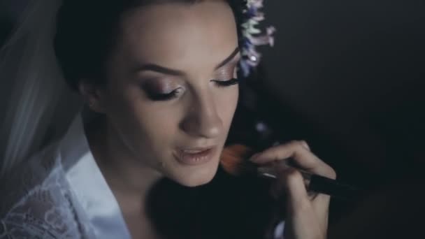 Hermosa novia con velo blanco hablando mientras artista maquillaje trabajando con cepillo. Preparación de la mañana antes de la boda . — Vídeos de Stock