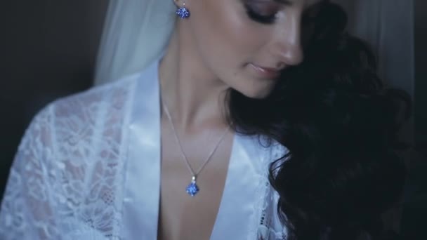 Portré, fiatal barna menyasszony elegáns fehér fehérnemű viselése peignoir. Gyönyörű kék szem mosolyogva nő.