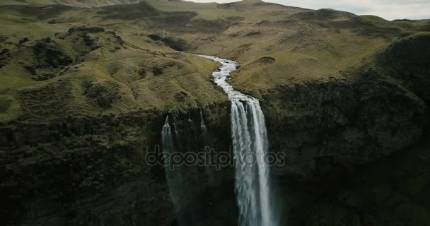 Dağlar nehre havadan görünümü vadi boyunca akar ve aşağı düşüyor. İzlanda'daki şelale Seljalandsfoss. — Stok video