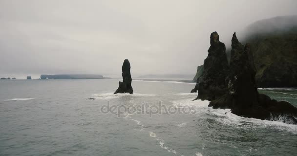 Εναέρια άποψη του τρολ πετρώματα δάχτυλα και μαύρη ηφαιστειακή παραλία στην Ισλανδία. Copter φέρουν πολύ κοντά από τα βράχια. — Αρχείο Βίντεο