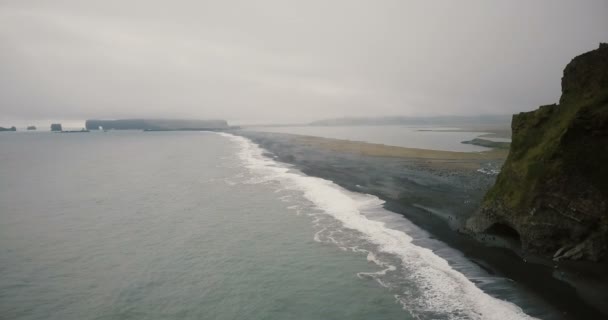 Εναέρια άποψη μαύρη ηφαιστειακή παραλία και στα βουνά κοντά στην θάλασσα στην Ισλανδία. Πλήθος τουριστών περπατώντας στην ακτή. — Αρχείο Βίντεο