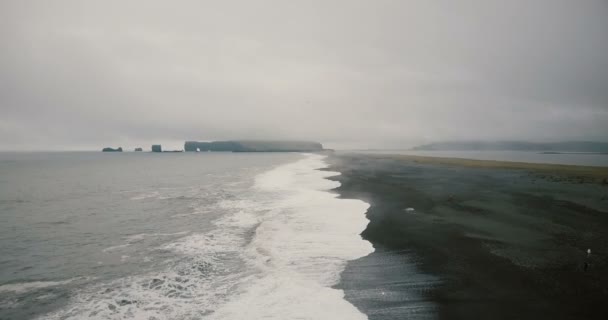 Copter volando sobre la playa negra volcánica de Islandia. Hermoso paisaje del agua, montaña, olas y niebla . — Vídeos de Stock