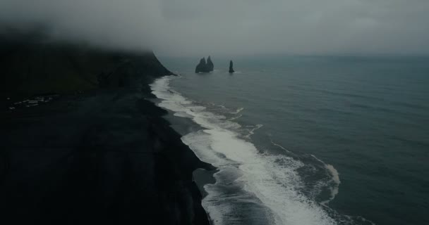 Vista aérea de la playa volcánica negra en Islandia y troll toes rocas en el mar. Copter volando sobre la ola con espuma . — Vídeos de Stock