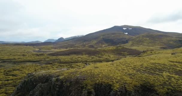 Drone flyger över fältet lava i Island. Flygfoto över det vackra landskapet på klipporna med knölar. — Stockvideo
