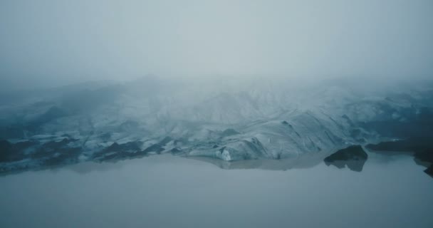 Luftaufnahme des weißen Gletschers Myrdalsjokull mit schwarzer Asche in Island. ewiges Eis im Nebel im Gebirge. — Stockvideo
