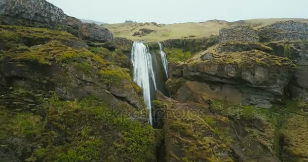 アイスランドの山の Gljufrabui の滝の空撮。流れ落ちて近くを飛んでいるヘリコプター. — ストック動画