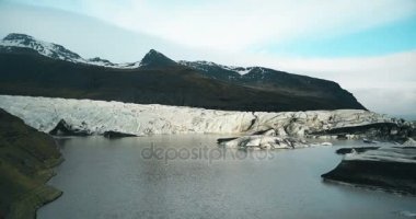 Göl ile buzdağı Vadisi'nin havadan görünümü. Güneşli bir günde büyük buzlu buzul Vatnajokull İzlanda üzerinde uçan helikopter