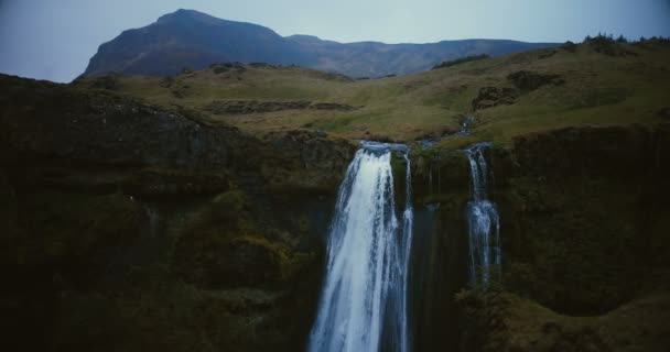 Вид з водоспадом Gljufrabui в Ісландії. Вертоліт літати біля річки падає з гори. — стокове відео