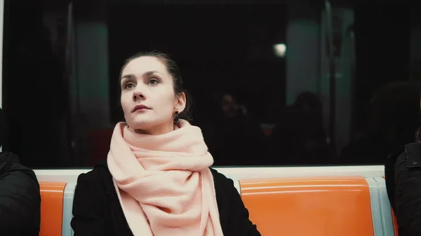 Portret van jonge mooie vrouw zitten in de metro. Aantrekkelijk meisje gaat aan het werk met het openbaar vervoer. — Stockfoto