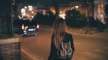 Gece geç saatlerde yürüyüş sırt çantası ile esmer kadın. Akşam şehir merkezine yakın yol çekici kız geçer.