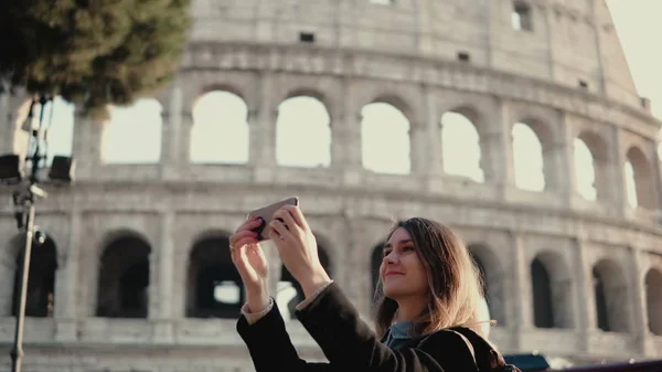 Giovane bella donna prende il selfie su smartphone. Donna che cammina a Roma, Italia vicino al Colosseo . — Foto Stock