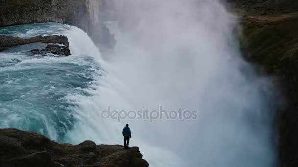 Tempo de queda de paisagem da cachoeira Gullfoss na Islândia e homem em pé na beira do penhasco, apreciando a vista . — Vídeo de Stock