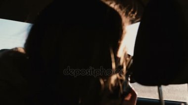 Arabanın içinde görüntüleyin. Araba ve pencerenin dışındaki günbatımı manzara fotoğraflarını alarak seyahat turizm kadın.