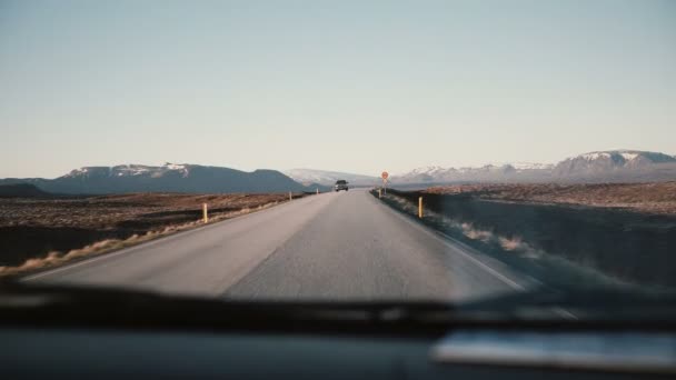 Blick im Auto durch die Windschutzscheibe auf schöne Landstraße mit wunderschönem Sonnenuntergang, Berglandschaft. — Stockvideo