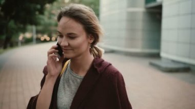 Belgili tanımlık smartphone kullanarak arkadaşlarınızla konuşurken genç güzel kadın portresi. Kadın ayakta dışında ve konuşma.