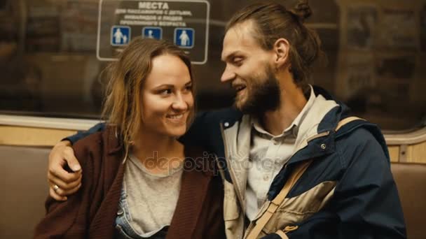 Jeune beau couple rentrant chez eux en métro ensemble. Heureux homme et femme parlant, assis sur le tas . — Video