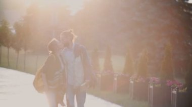 Genç güzel çift şehrin içinden yürümek yağmur altında merkezi. Mutlu bir adam ve kadın sunset bulvarında öpüşme.