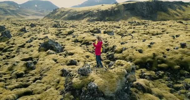 两个快乐的女人站在冰岛的熔岩场的鸟瞰图, 并在智能手机上制作自拍照片. — 图库视频影像