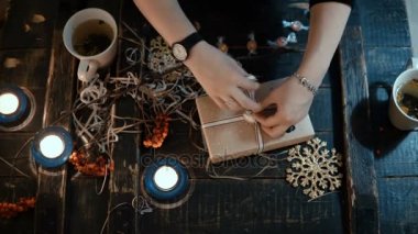 Eller en iyi yakından görmek bir kutu Noel hediyesi oturma masada dekorasyon bir kurdele ile bağla.