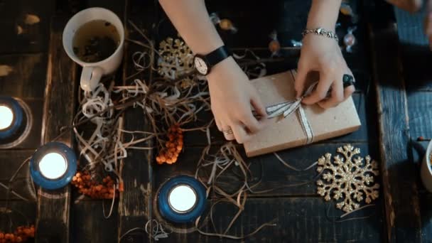 Top view of young couple sitting at the table with holidays Christmas decoration and opening the box together. — Stock Video