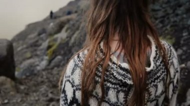 Esmer kadın saç rüzgarda sallayarak yakından görmek. Dağlarda hiking lopapeysa kazaklı genç kadın.