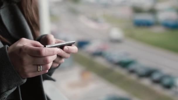Detailní pohled na ženské ruce držící smartphone, mladá žena, procházení Internetu mimo z mobilního telefonu. — Stock video