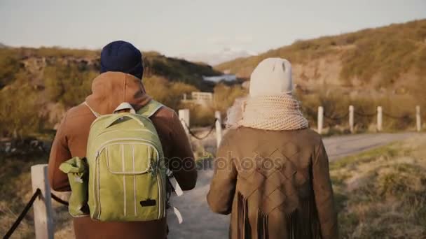 Vista posterior de la pareja joven tienen una cita romántica en la naturaleza.Viajar hombre y mujer senderismo en el valle de las montañas , — Vídeos de Stock