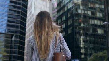 Belgeleri holding ve ofis binası New York, ABD'de olacak genç iş kadını arkadan görünüm. Ağır çekim.
