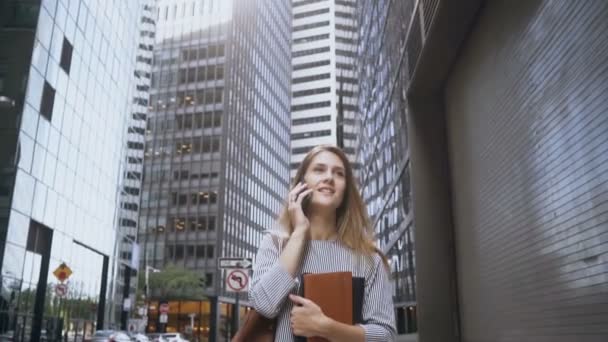 Joven mujer de negocios ocupada hablando por teléfono móvil y yendo a trabajar a través del distrito financiero de Nueva York. Lento mo . — Vídeos de Stock