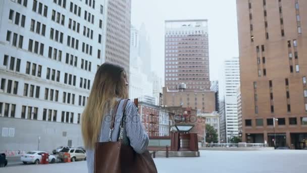 Молодая успешная женщина, держащая документы и идущая на работу в офис в Нью-Йорке, Америка. Медленное движение . — стоковое видео