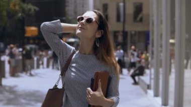 Belgeleri holding ve kahve molası şehir merkezinde yürüyüş genç güzel işkadını portresi. Ağır çekim.