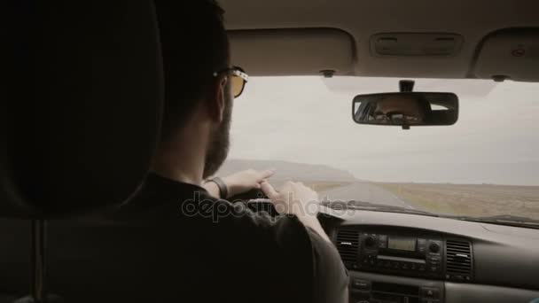 Kijk binnenin de auto. Twee man rijden de auto via de lege weg. Vrienden in zonnebril samen reizen. — Stockvideo