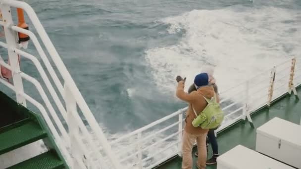 Draufsicht auf ein junges Paar, das an Bord des Schiffes steht. Mann und Frau mit Rucksack erkunden Island. — Stockvideo