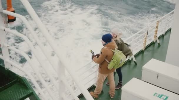 Vue de dessus du jeune couple debout à bord du navire. Homme et femme avec caméra d'action profitant de la vue sur la mer . — Video