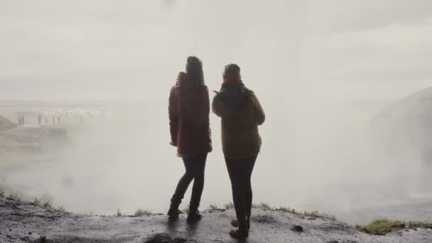 アイスランドの Gljufrabui の近くに立って 2 つの幸せな女性の後ろ姿。女性は、有名な観光スポットを探索の旅. — ストック動画