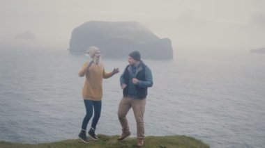 Genç şık çift birlikte eğleniyor. Erkek ve kadın deniz kıyısında sisli gün dans.