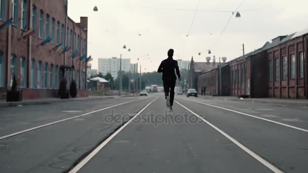 Ο άνθρωπος που τρέχει κατά μήκος μιας παλιάς δρόμου πόλης. Πίσω όψη. Στο δρόμο προς την επιτυχία και την επίτευξη των στόχων. Shot αντίθεση. — Αρχείο Βίντεο