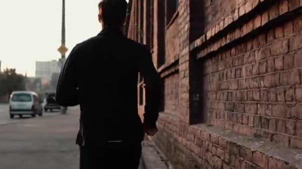 Deportista en tiempo real corriendo rápido en una calle vieja. Joven entrenador de fitness masculino libre determinado profesional. Vista trasera . — Vídeos de Stock