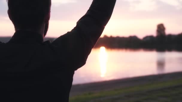 슬로우 모션 남자 조용한 강 근처 워밍업입니다. 다시 보기 남성 스윙 팔, 아름 다운 아침 물 파노라마 점프. — 비디오