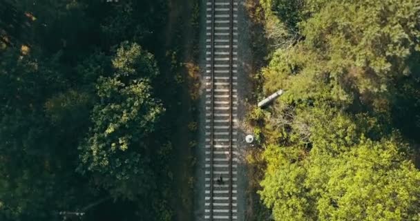 Vista aérea del hombre corriendo en la vía del tren. Vista vertical del dron. Concepto de perseguir sueños y sobrevivir a pruebas de vida . — Vídeos de Stock