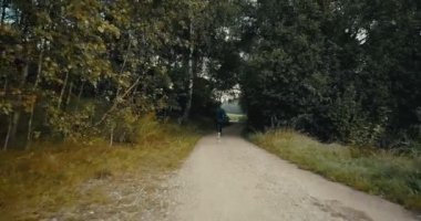 Ağır çekim runner karanlık sonbahar orman yolu üzerinde. Drone arkadan görünüm. Zor birazdan motive yaşam tarzı atlet.