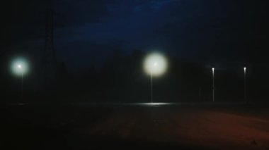 Atmosferik karanlık gece otoyola kadar geliyor bir araba. Güzel gizemli sinematik çekim. Gökyüzü. Bokeh şehir ışıkları.