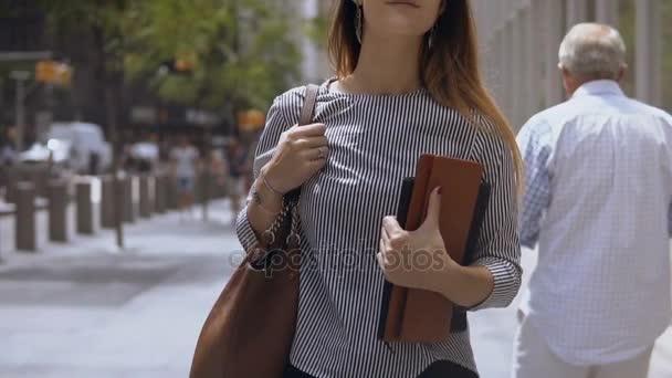 Junge schöne Frau, die auf der Straße geht. Stilvolle Geschäftsfrau, die Dokumente hält und zur Arbeit geht. Zeitlupe. — Stockvideo